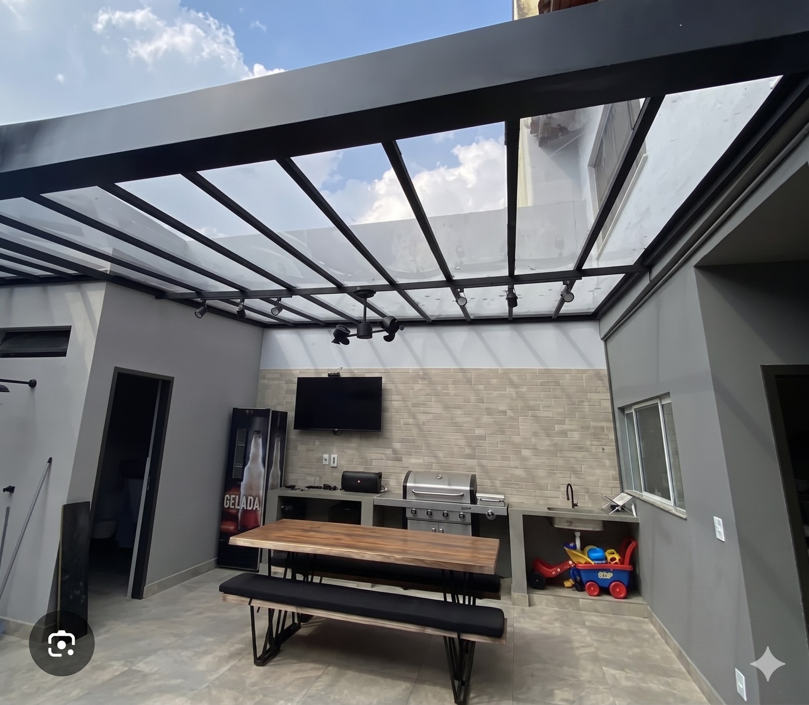 Toldo retrátil preto instalado em residência moderna